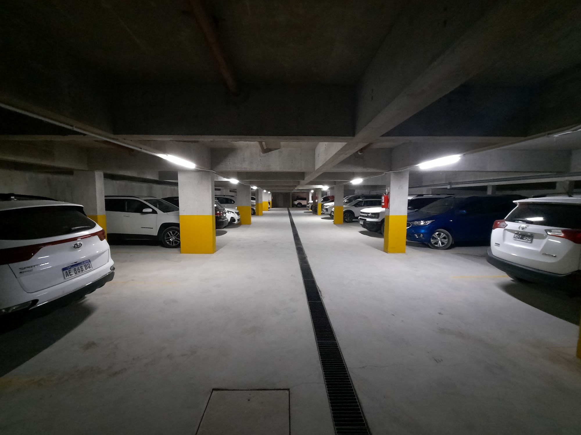 Cochera subterránea del edificio, con autos estacionados.