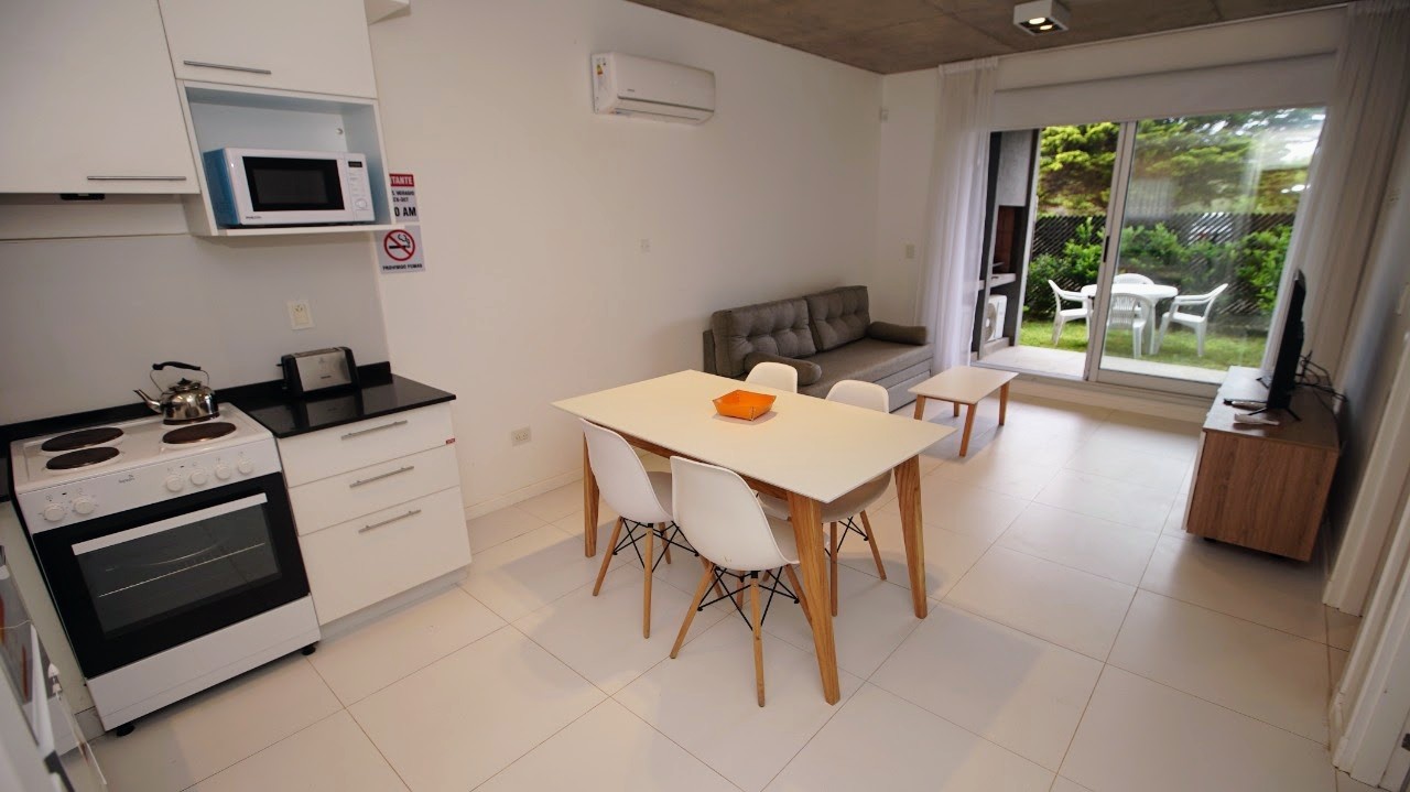 Cocina integrada al comedor, con salida directa al deck y al jardín.