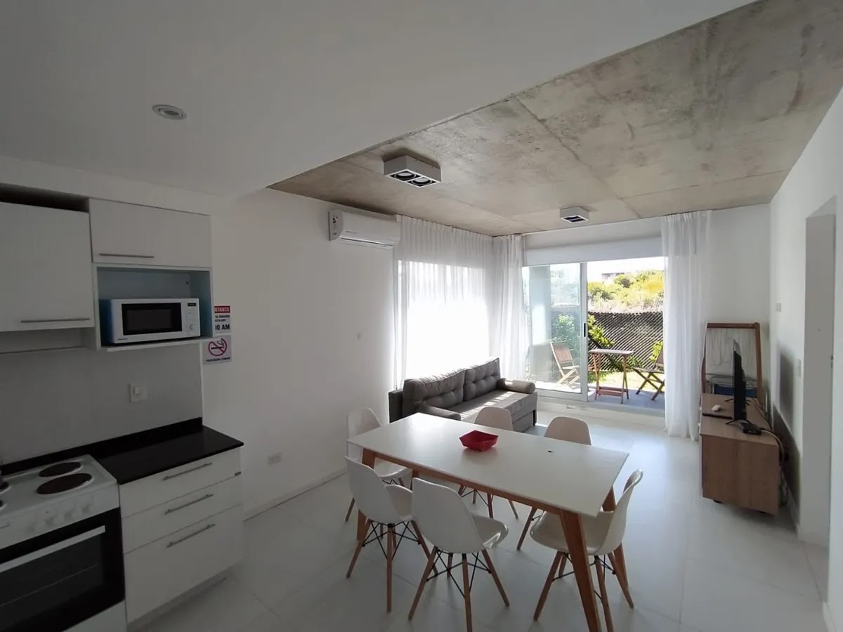 Cocina abierta al comedor, con mesa y sillas.